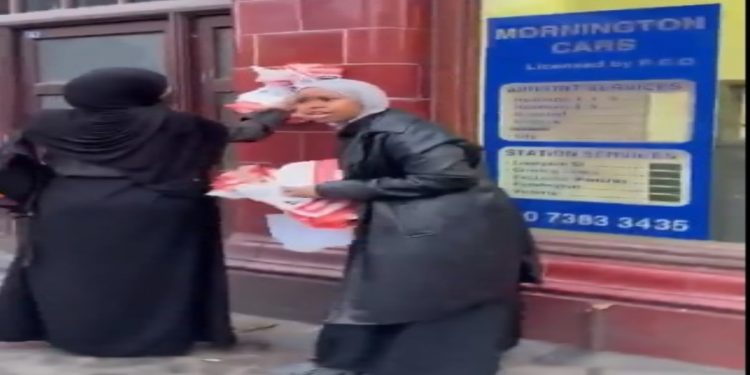 Muslim Women In London Tear Down Pictures and Names of Missing Israelis